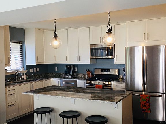 Updated kitchen with granite countertops, gas range, Bosch dishwasher, microwave, and LG refrigerator.