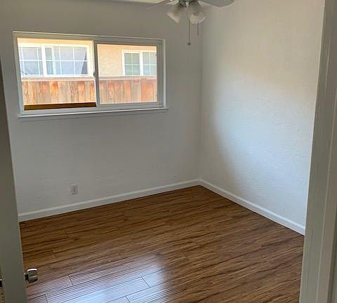 bedroom 1, hardwood floor, fresh paint, mirrored closet, ceiling fan
