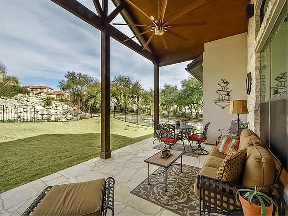 Outdoor living with wooden ceiling and stone flooring.
