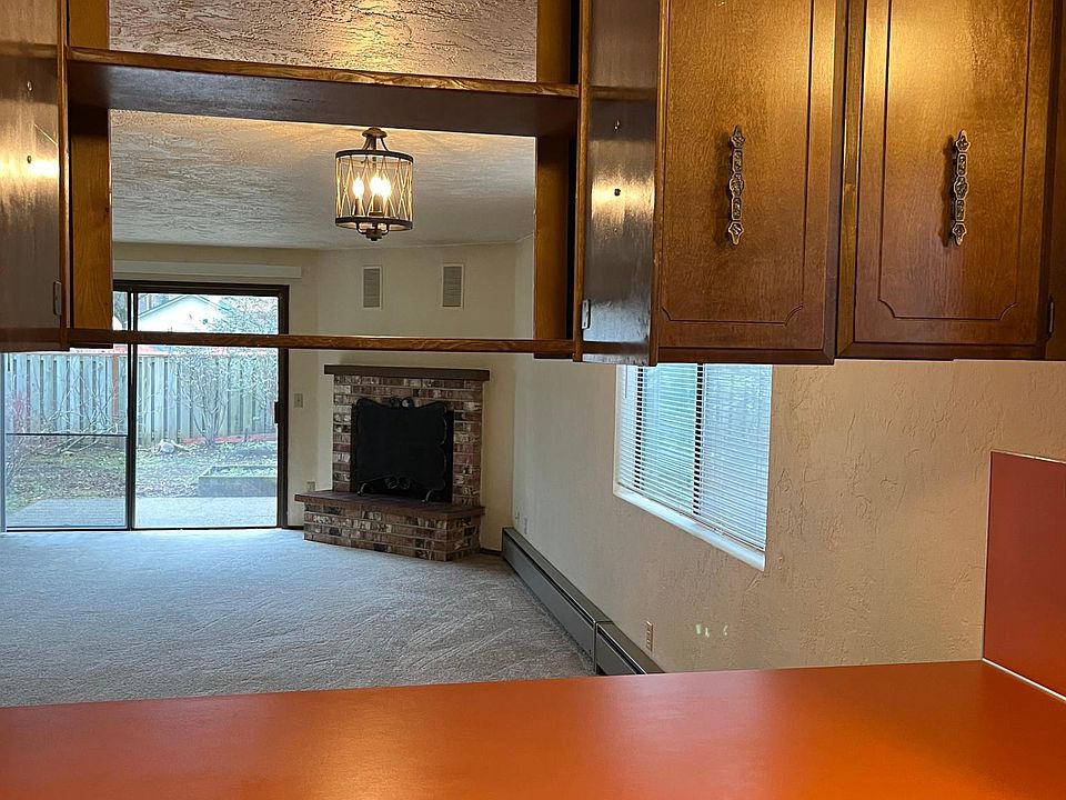 ( actual unit layout is opposite) View from kitchen into open plan living room with wood burning fireplace (fireplace use is emergency secondary heat only)