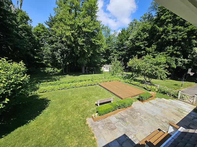 View from Bedroom 4 overlooking the backyard and surrounding trees.
