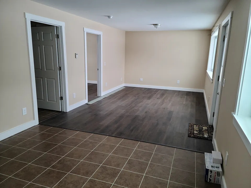 Looking from dining area toward livingroom.
Door to outside on right.
1st door on left is bathroom.
2nd door on left is bedroom.