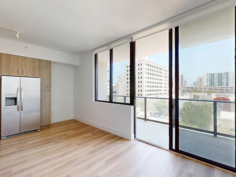 Apartment Kitchen Stainless Steel Appliances, large windows, Dining and Living Room with wood-style flooring
