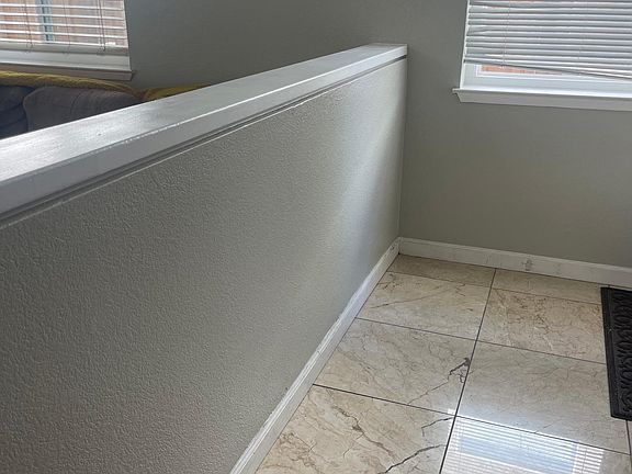 At the front entrance, a step down off the marble tile that leads to the family room. Alternatively, you can turn left and go upstairs to the bedrooms.