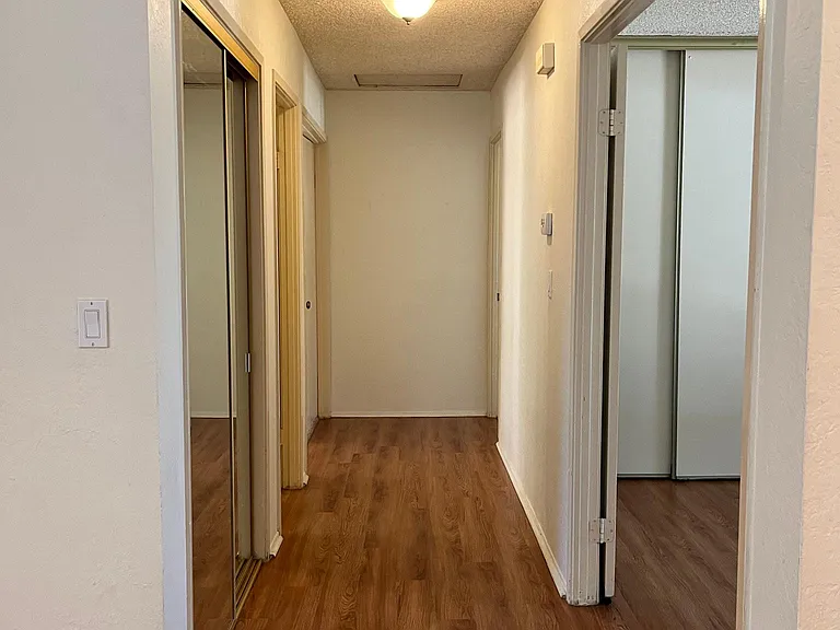 Hallway with large storage area and mirrored doors