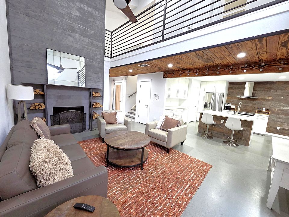 Living room with concrete wall fireplace and blow torched wood ceiling