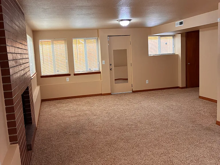 Bottom living area with fireplace. Primary bedroom to right in picture.