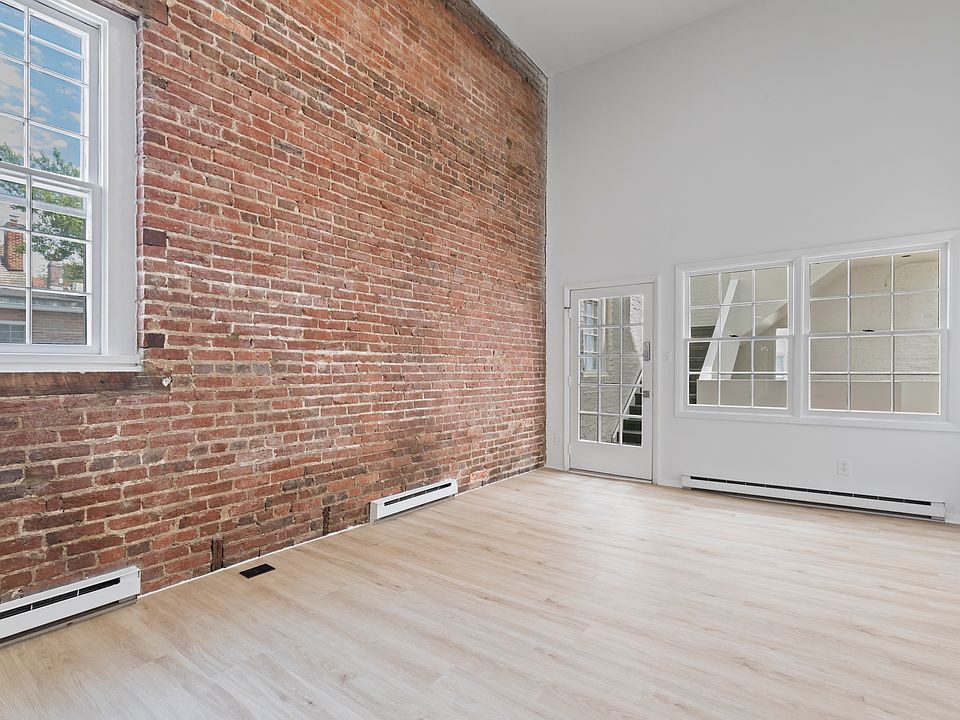 Unit #210 living room with exposed brick wall.
