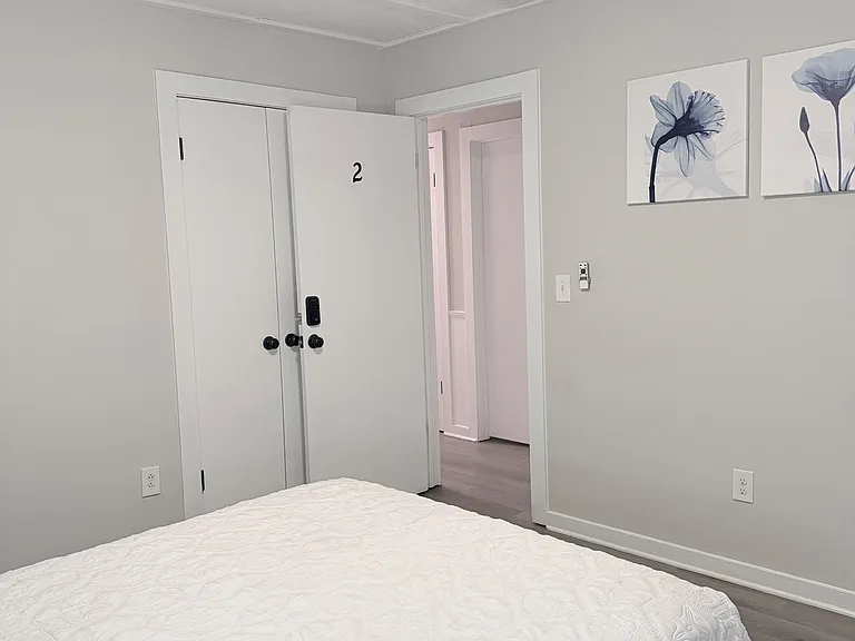 Private bedroom with a ceiling fan, neutral finishes, and convenient access to the hallway and closet storage.