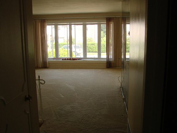 LARGE OPEN SECOND FLOOR FAMILY ROOM FEATURING LUSH CARPETING AND SWEEPING VIEWS OF OUTDOORS
