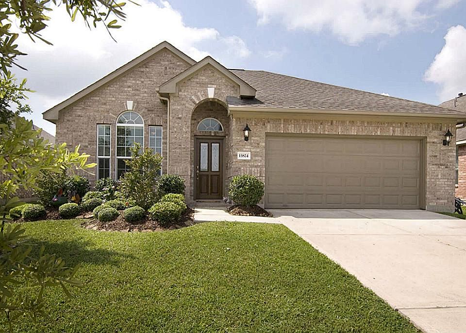The front is nicely landscaped and has an inviting arched entry.