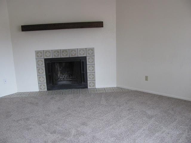 Wood burning fireplace in living room. New carpets.