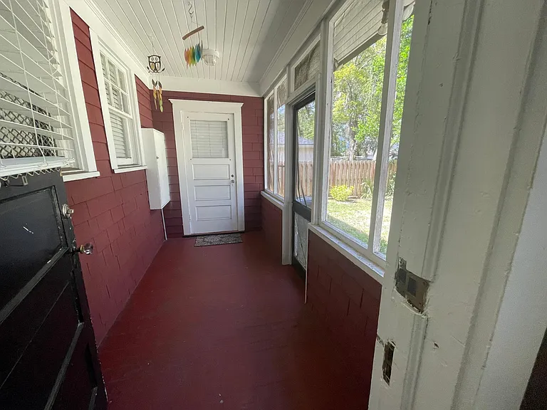 view out the backdoor into the screened in shared back porch.