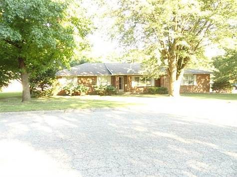 Brick home facing the West, larage shade trees in front and back of home.