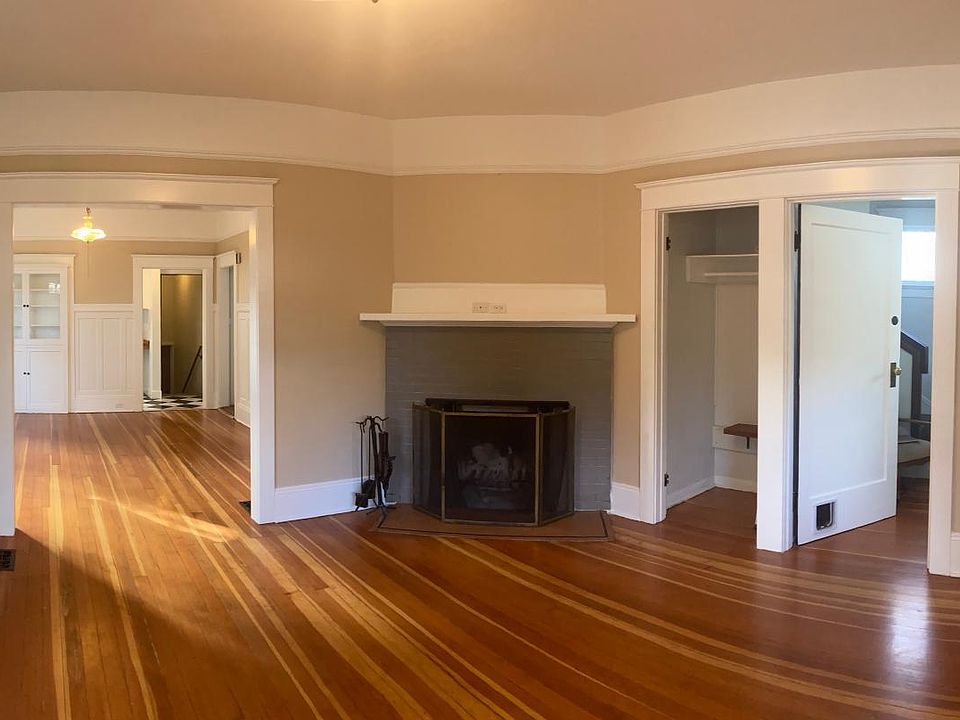 Living room with original hardwoods and fireplace.
