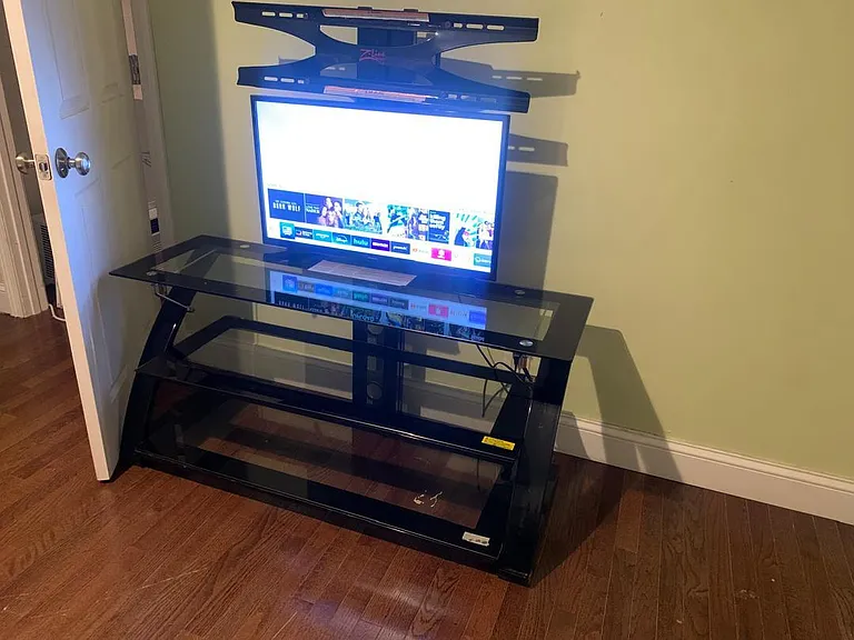Common area with hardwood floors and a media setup, offering space for relaxing and everyday entertainment.