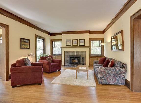 Large living room with a wood burning insert and plenty of space for a piano or second sitting area.