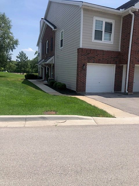 View of the first floor unit - door at the end of the sidewalk - garage is the second one from the left.