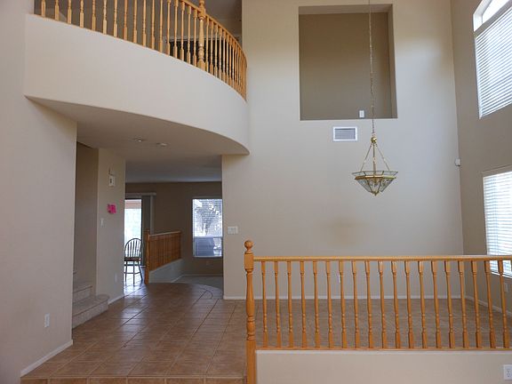 Formal dining area w/ vaulted ceiling, pendant chandelier, 2nd floor overlook.