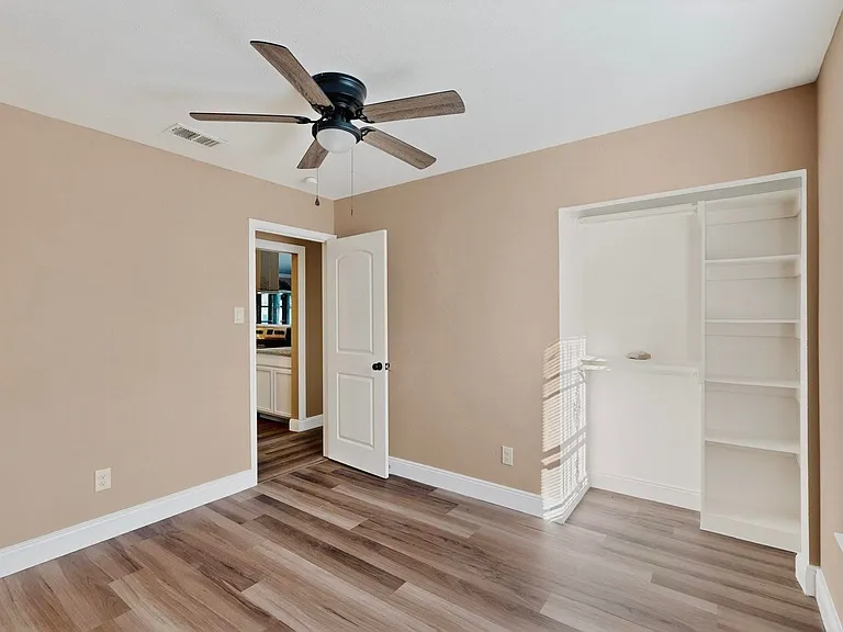 Unfurnished bedroom featuring light wood finished floors, ceiling fan, and a closet