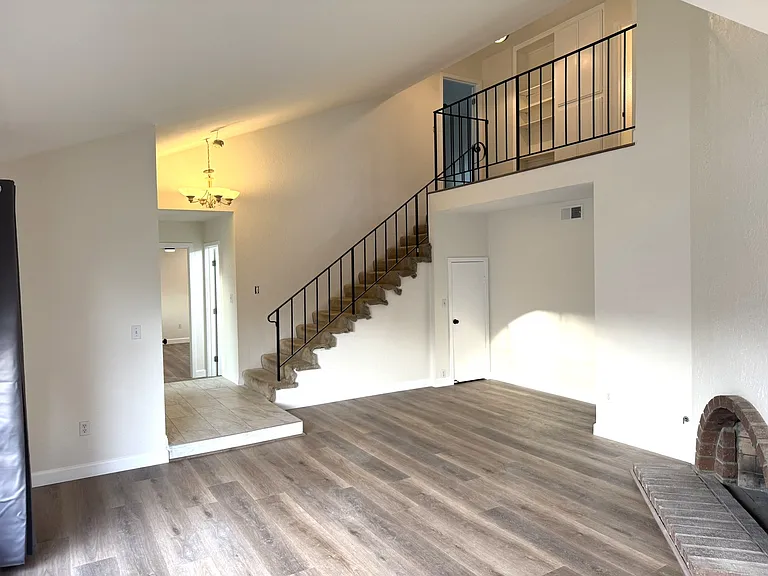 Living room with entry at the bottom of stairs leading to two very large bedrooms and a full bath