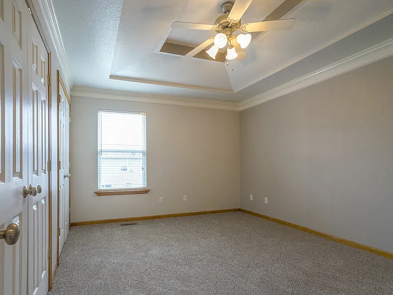 Primary bedroom with coffered ceiling and crown molding