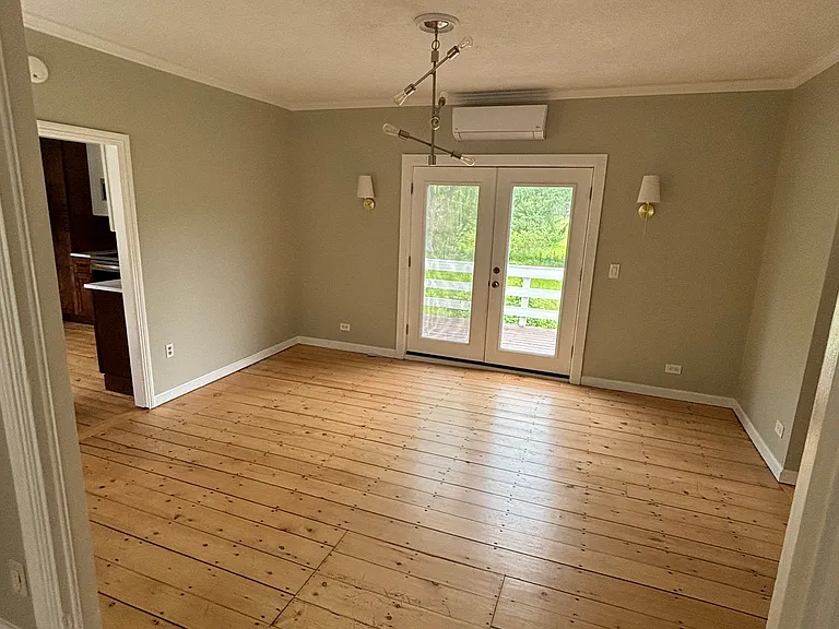 Dining area connected to kitchen, living room, and first downstairs bedroom