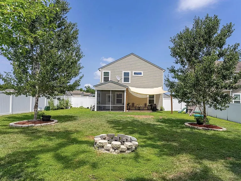 Fenced in back yard with fire pit.
