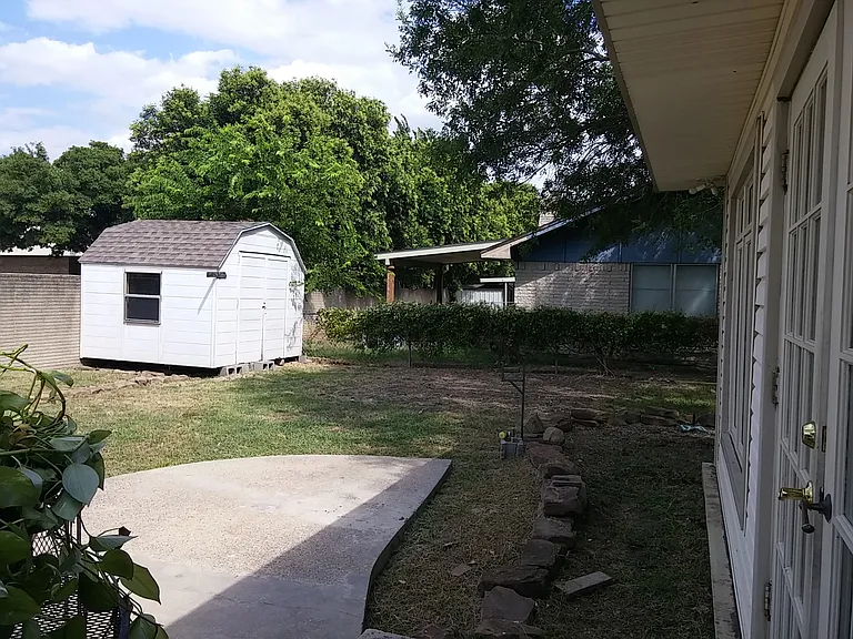Back yard, patio view outside French doors. Large shed.