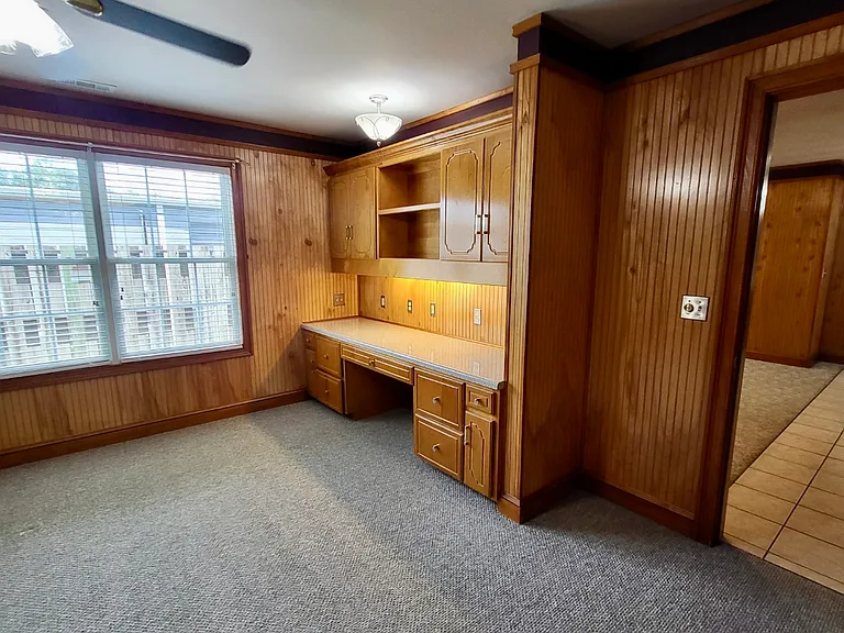 Custom shelves and large study desk with cabinets and LED lighting.