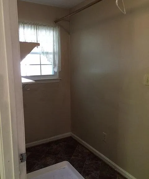 The laundry room is large enough for a side-by-side washer and dryer. Above the wall hook-ups, there are cabinets and shelving.