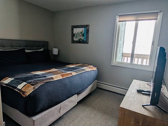 Master bedroom with dresser, TV and half bath