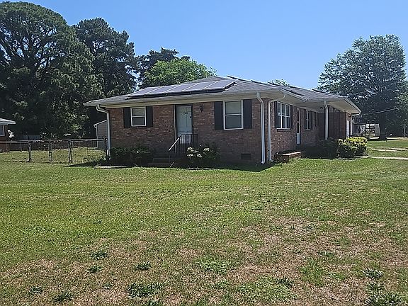 Private side entrance with convenient mailbox access and spacious open yard, offering both functionality and easy outdoor accessibility.