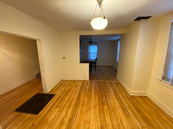 Living room leading into kitchen area and the far left is a stairway leading upstairs