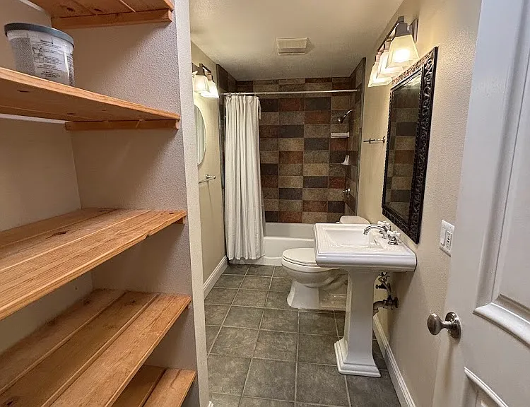 Downstairs guest bathroom with storage shelves
