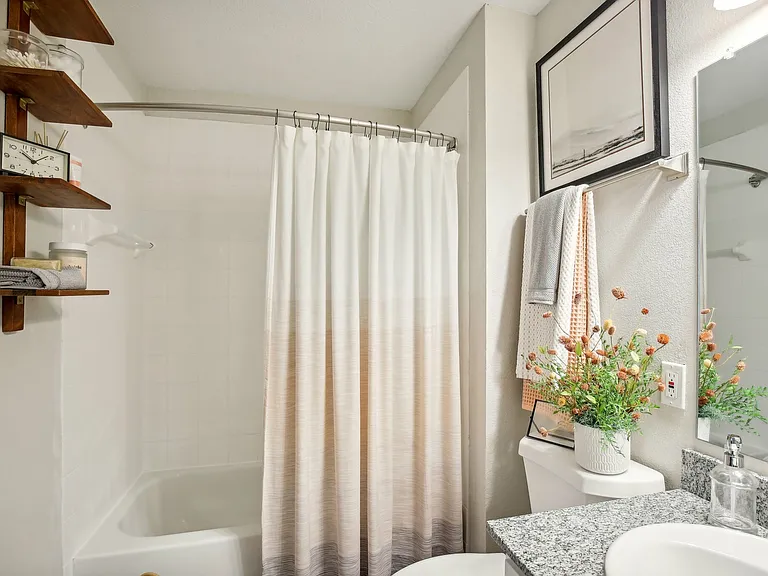 Refresh your routine in a modern bathroom with granite countertops and sleek white cabinetry at The Preserve Murfreesboro apartments.