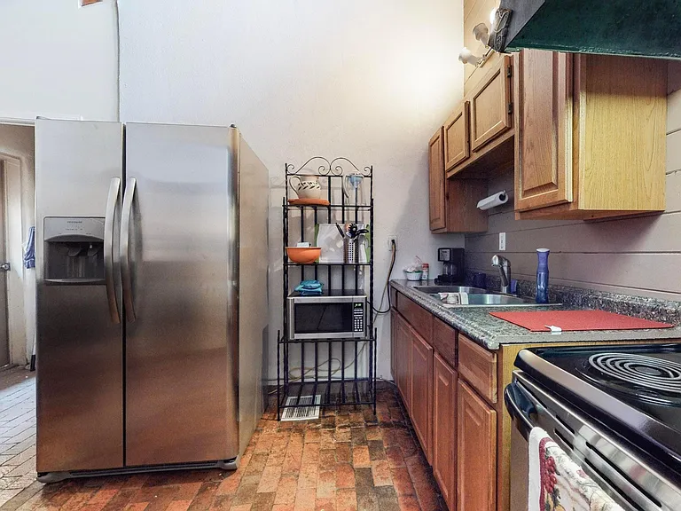 Kitchen with a table that seats four. Microwave, Stove, Electric Range, and stainless steel refrigerator.