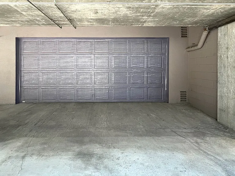 Attached private 2-car garage with automatic overhead door, remote opener, secure parking, and convenient home access.
