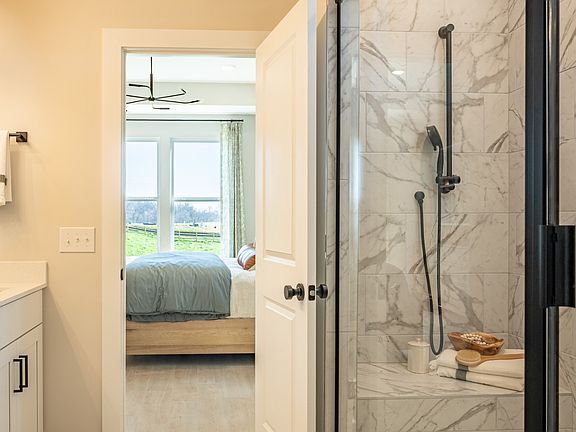 Bathroom with walk-in shower and dual vanity opening into the primary bedroom