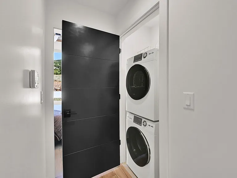 Hallway closet with stacked washer and dryer