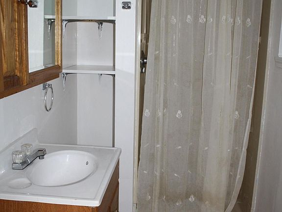 Bathroom with shower, built in shelving (toilet  is behind p