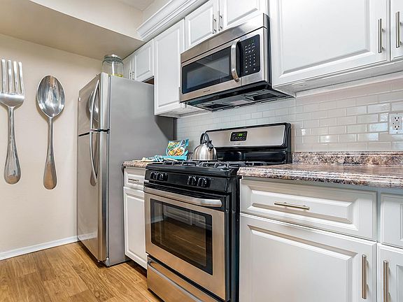 Newly remodeled kitchen featuring granite-style counter-tops, a back-splash, and stainless steel appliances.