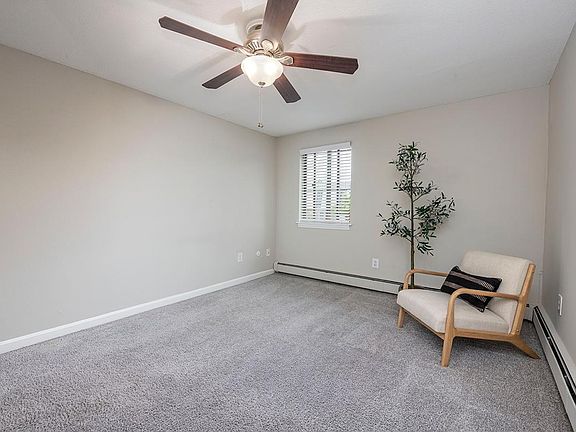 Spacious bedrooms with plush carpeting and a ceiling fan.