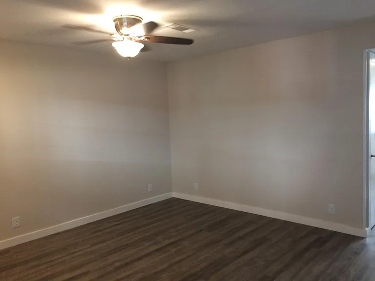 View of living room with ceiling fan.