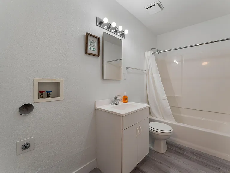 Bathroom 1 features a convenient washer and dryer integration, making laundry a breeze in this functional space.