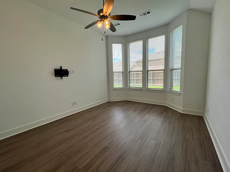 Primary bedroom with room for king size bed, two side tables, a dresser, and more.