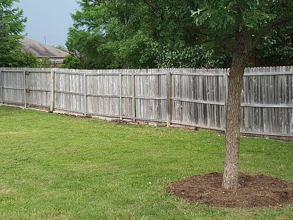 Large trees bound the yard. Neighbor's trees provide privacy on West Side.
