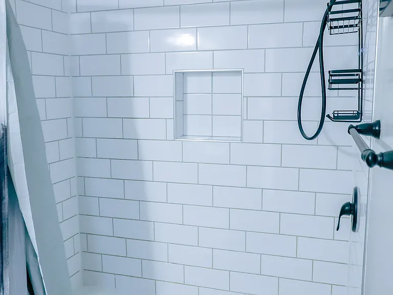 Beautifully updated shower with classic subway tile, built-in niche, and modern matte black fixtures for a sleek, contemporary finish.