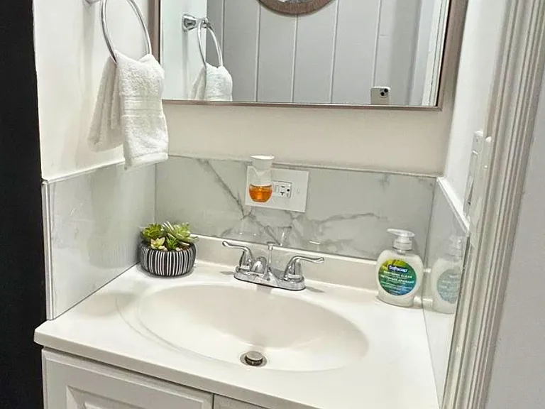 Pristine bathroom with modern vanity, shower, and toilet.