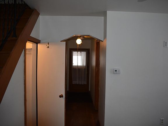 View showing main hall leading to door to summer room. This is the primary access point. The door to the left leads down steps into the lower area. The steps to the left lead to the upstairs bedroom that is 25x12, the ceiling is contoured to the roof l